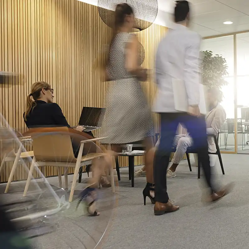 People walking through a busy office
